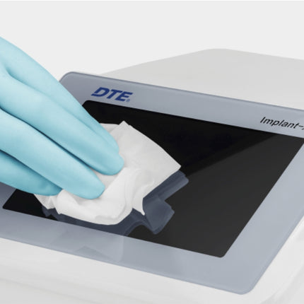 Reinigung des Touch-Displays am Woodpecker Implanter mit Desinfektionstuch und Untersuchungshandschuh